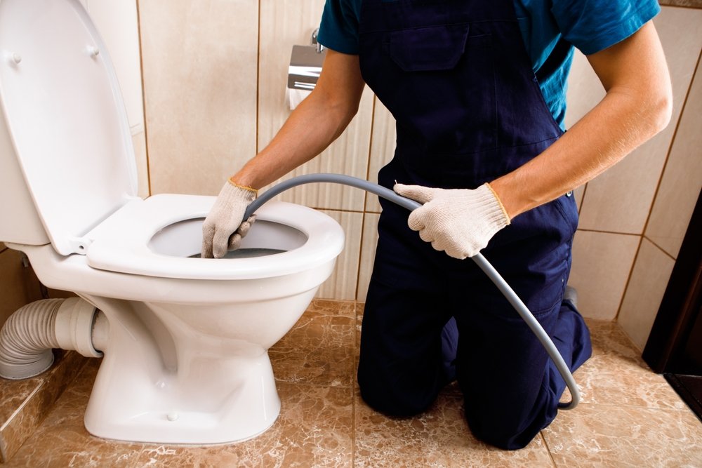 plumber,unclogging,blocked,toilet,with,hydro,jetting,at,home,bathroom.