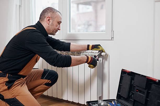 Ein professioneller Techniker tauscht alte Heizkörperthermostate effizient und sicher aus.